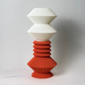 Two layered lamp with white top and terracotta bottom on a plain background