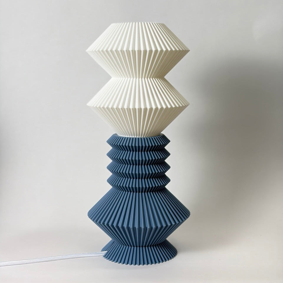 Two-tiered lamp with white top and blue bottom on a light gray background