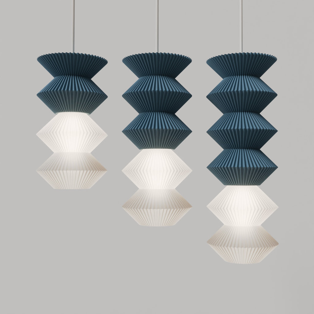 Set of three pendant lights with blue and white designs on a gray background